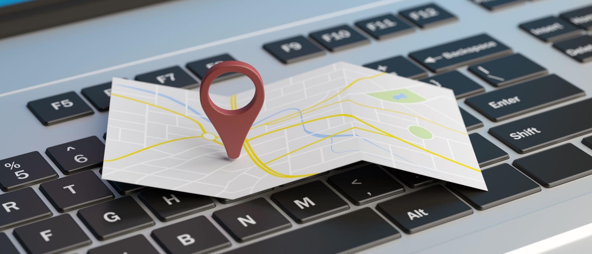 3D map pin on laptop keyboard showing local search strategy by SEO experts near me to rank higher on Google Maps.
