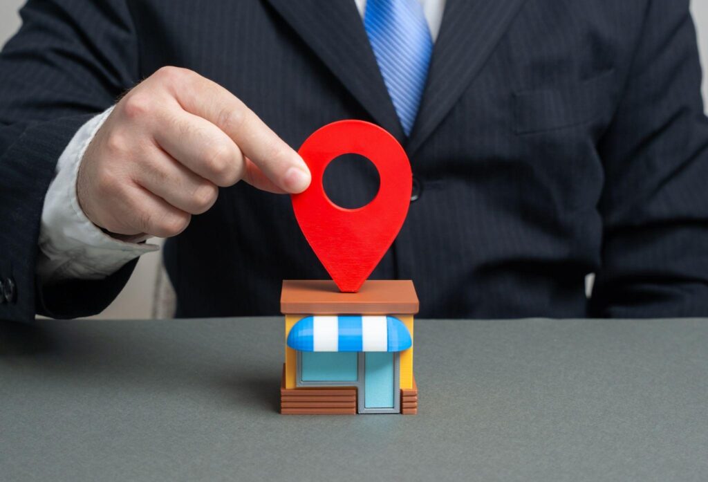 Business owner placing a location pin on a small storefront, symbolizing how to rank higher on Google Maps for startups and local businesses.